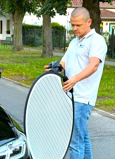 Ein Gutachter fotografiert den Schaden am Auto in Berlin vor Ort beim Kunden.